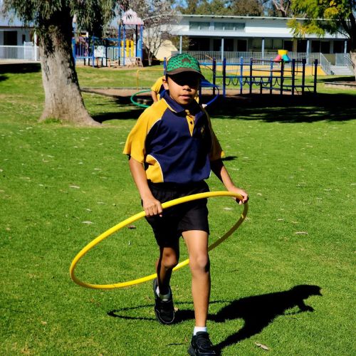 A young person with a hula hoop at Moree Public School