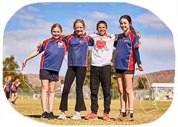 four school kids with arms around their shoulders