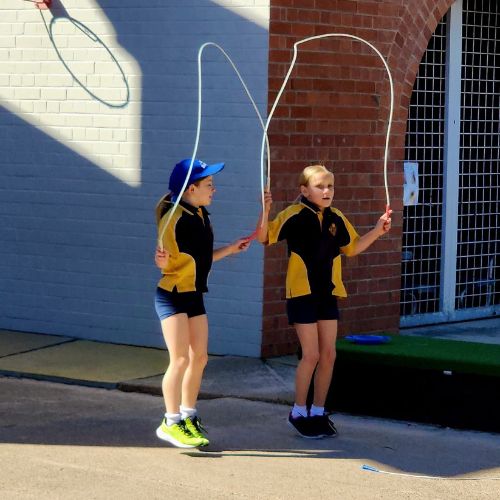 Two young people skipping rope at Moree Public School