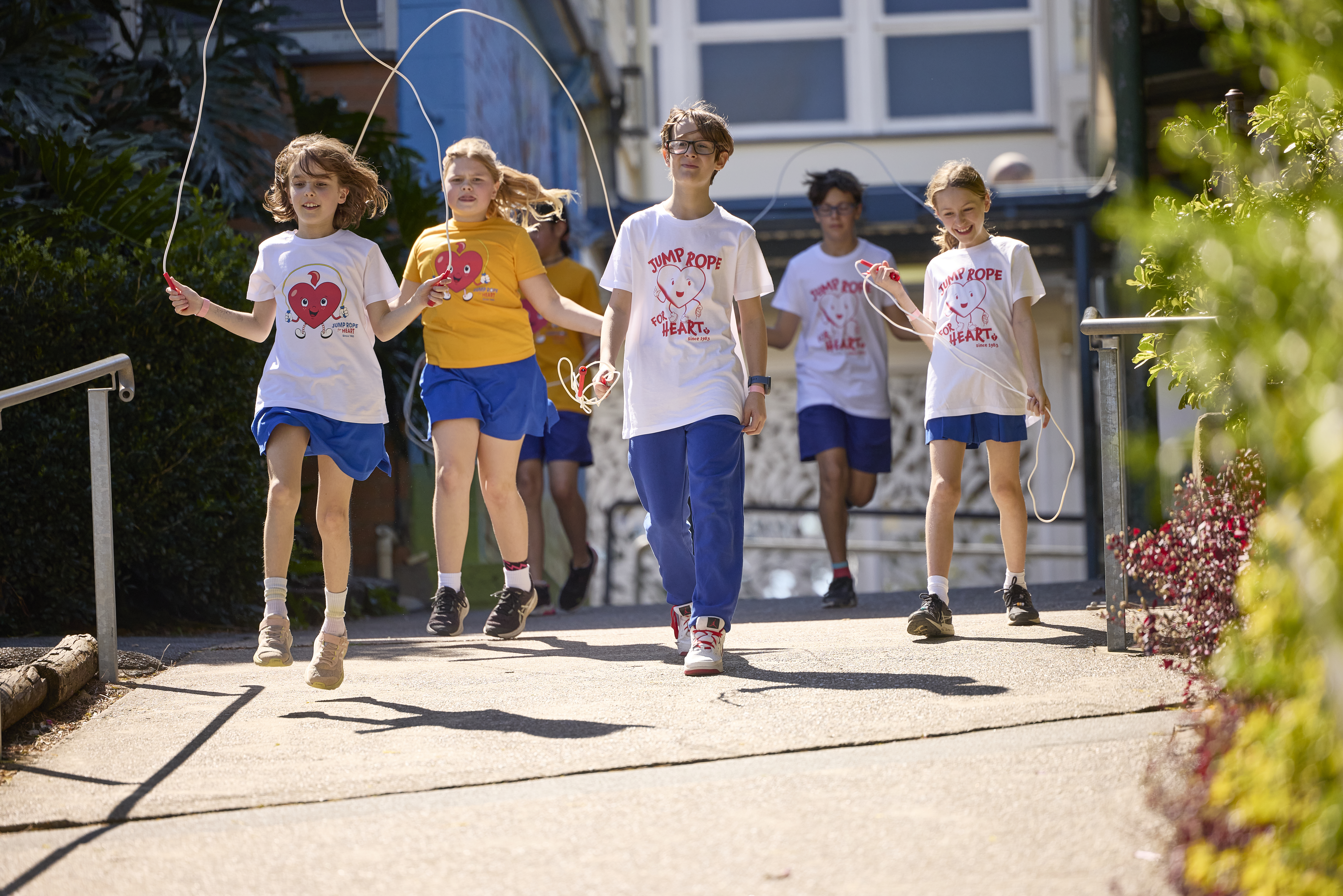 Group of happy kids skipping and walking in the sun
